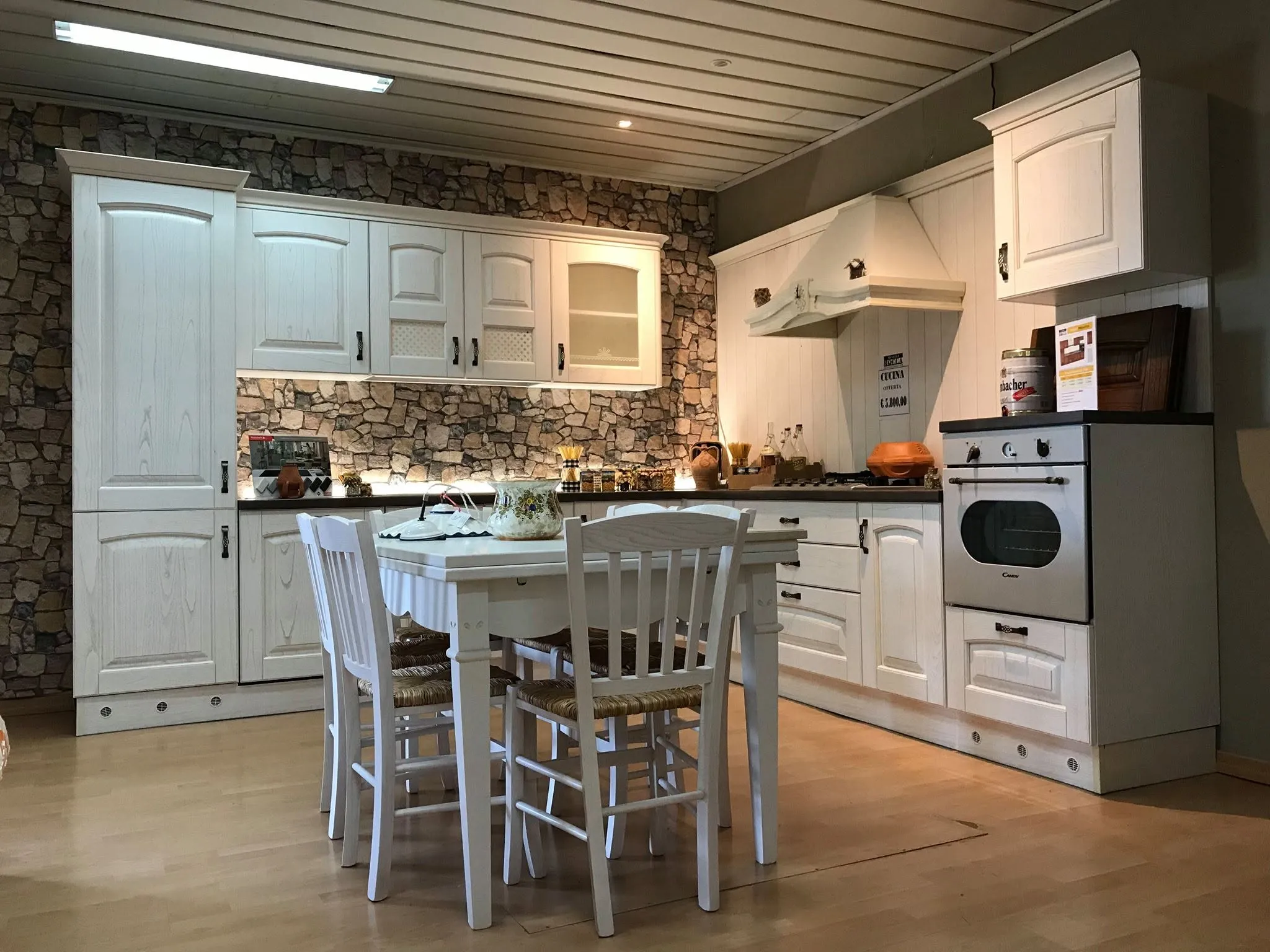 Cucina classica in legno bianco con parete in pietra